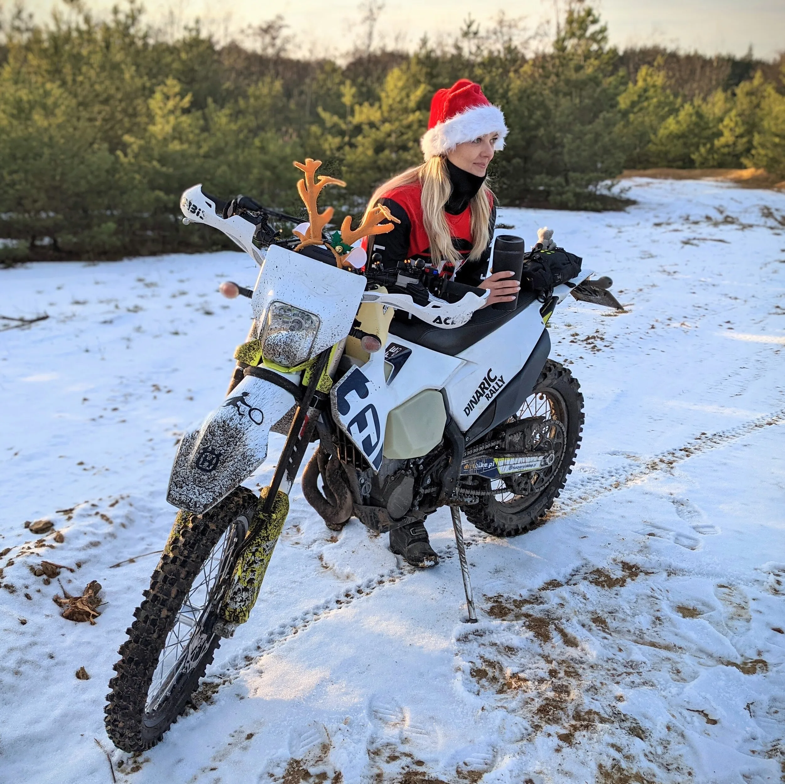 Motocyklistka w czapce Mikołaja na Husqvarnie FE 450 w śniegu